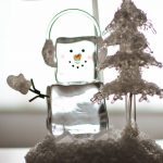 ice snowman next to an xmas tree