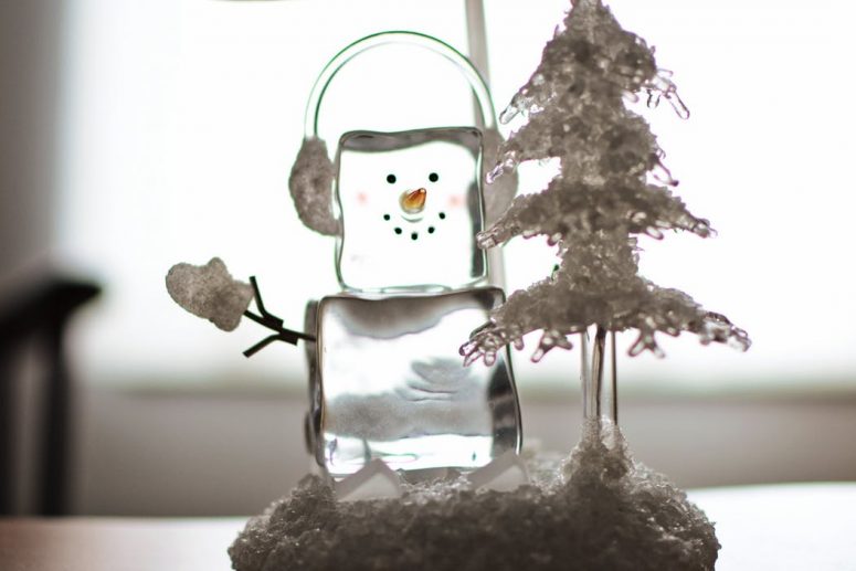 ice snowman next to an xmas tree